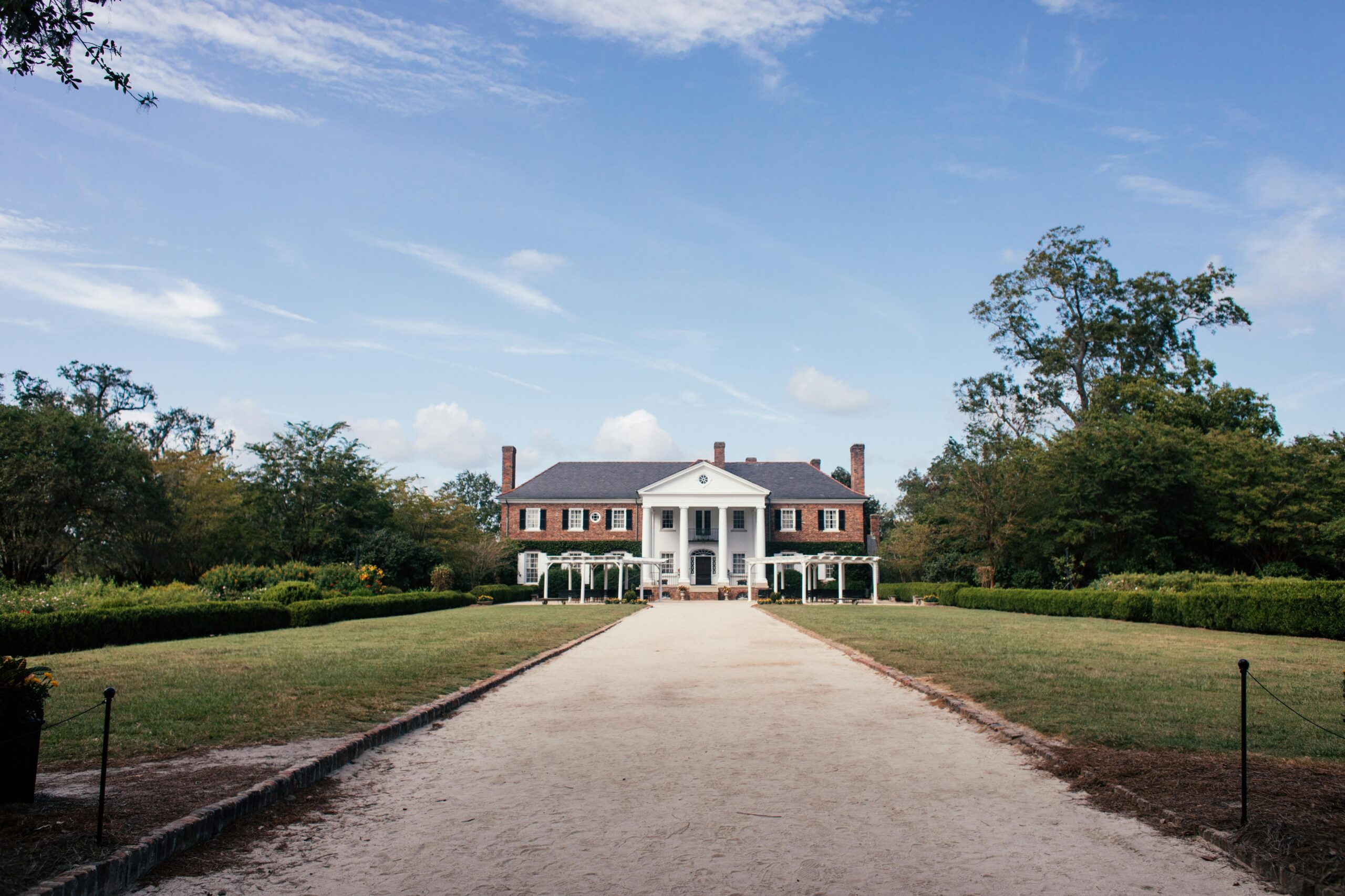 Picturesque view of Boone Hall Plantation's historic mansion in South Carolina under a blue sky.